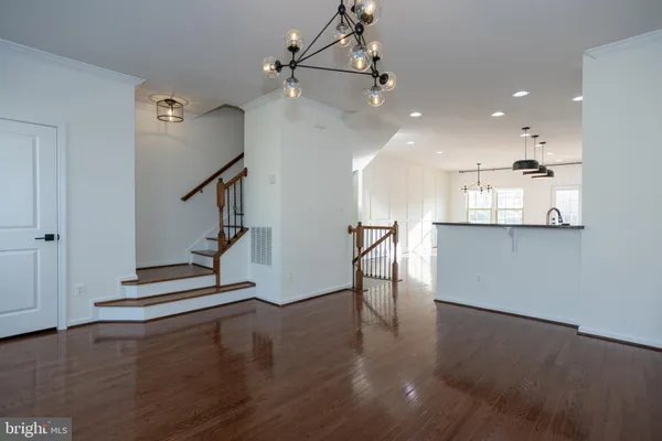 a kitchen with stainless steel appliances kitchen island granite countertop a stove a refrigerator and a wooden floor