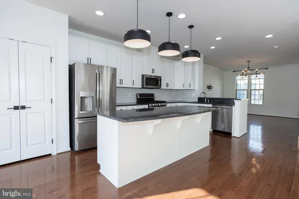 a kitchen with granite countertop white cabinets and black appliances