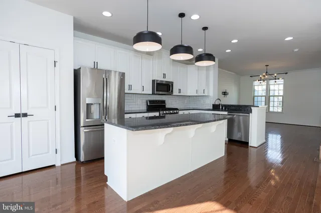 a kitchen with granite countertop white cabinets and black appliances