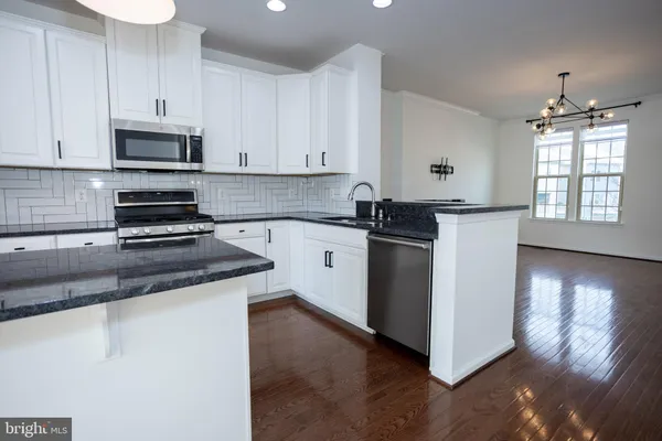 a kitchen with stainless steel appliances granite countertop a stove a refrigerator and a microwave