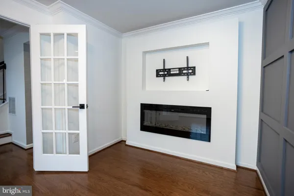 a view of a livingroom with wooden floor and a fireplace