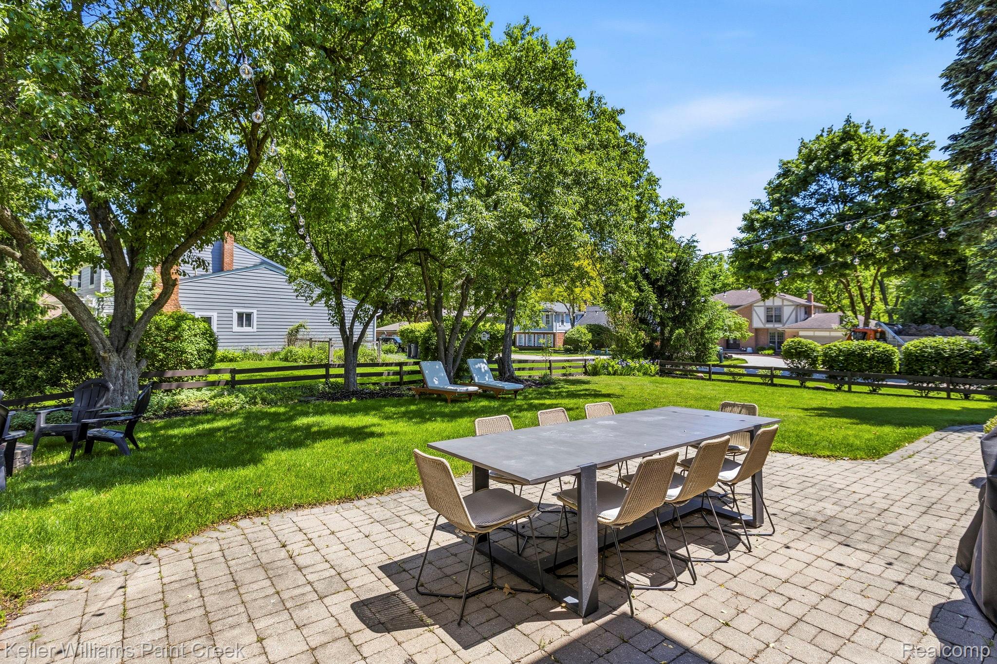 1675 North Kilburn Road Rochester, MI 48306 - Photo 9 of 48 Paver patio with a dining area, expanding to a manicured lawn