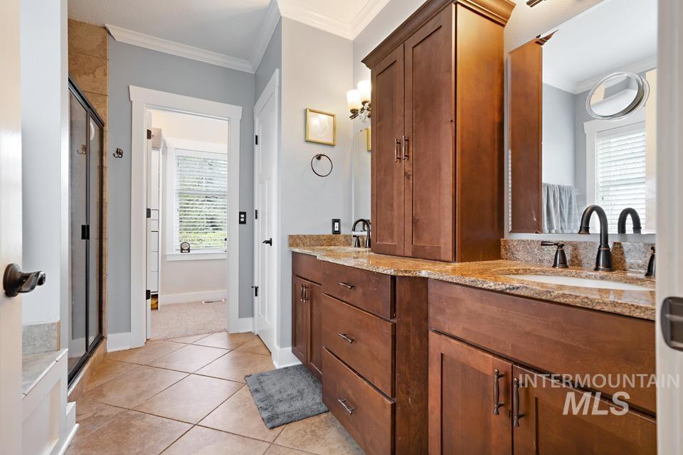 8271 Washoe Road Fruitland, ID 83619 - Photo 20 of 29 Dual vanity with granite countertops, rich wood cabinetry, and oil-rubbed bronze fixtures