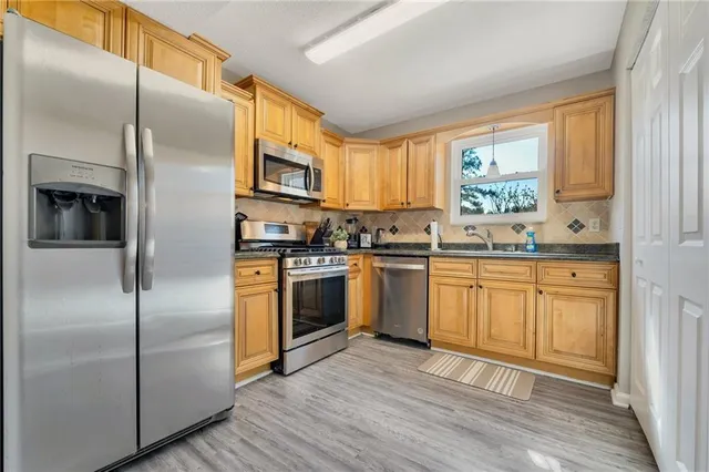 a kitchen with stainless steel appliances a refrigerator sink and microwave