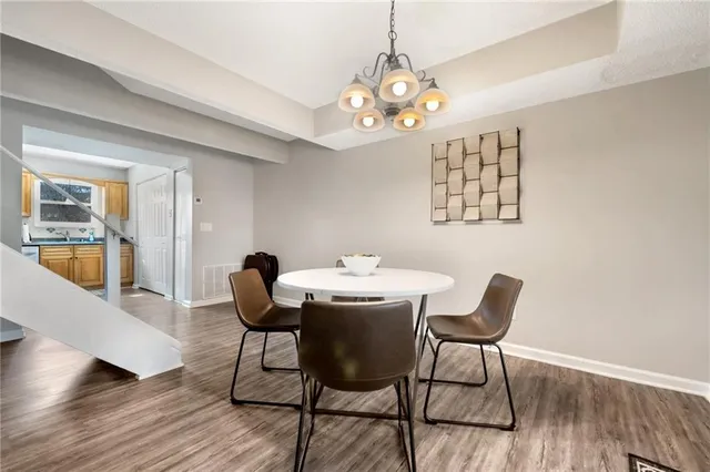 a dining room with furniture a chandelier and wooden floor