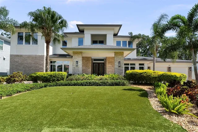 a front view of a house with a garden and plants