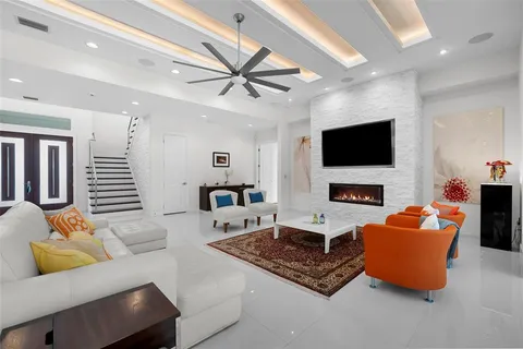 a living room with furniture a fireplace and a flat screen tv