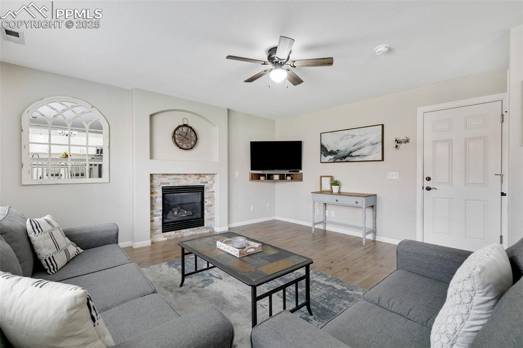 3615 Bareback Drive Colorado Springs, CO 80922 - Photo 15 of 27 a living room with furniture a fireplace and a flat screen tv