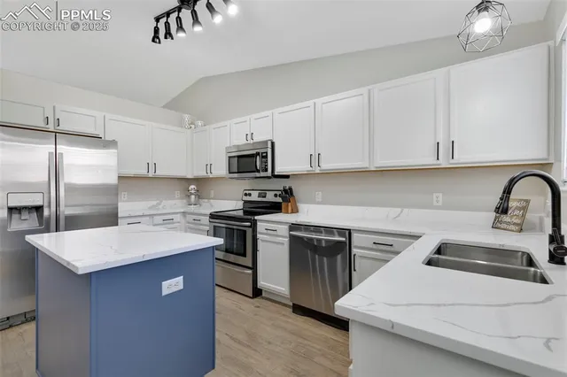 a kitchen with stainless steel appliances a sink stove refrigerator and cabinets