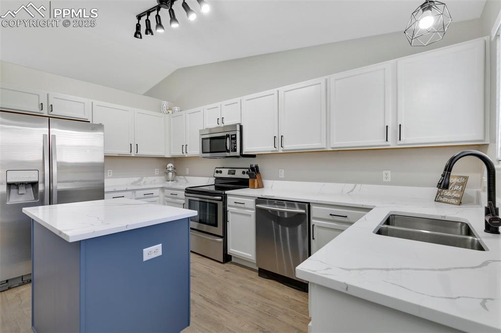 3615 Bareback Drive Colorado Springs, CO 80922 - Photo 9 of 27 a kitchen with stainless steel appliances a sink stove refrigerator and cabinets
