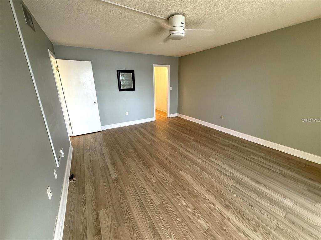 4775 Cove Circle, Unit 202 St. Petersburg, FL 33708 - Photo 11 of 19 wooden floor in an empty room with a window