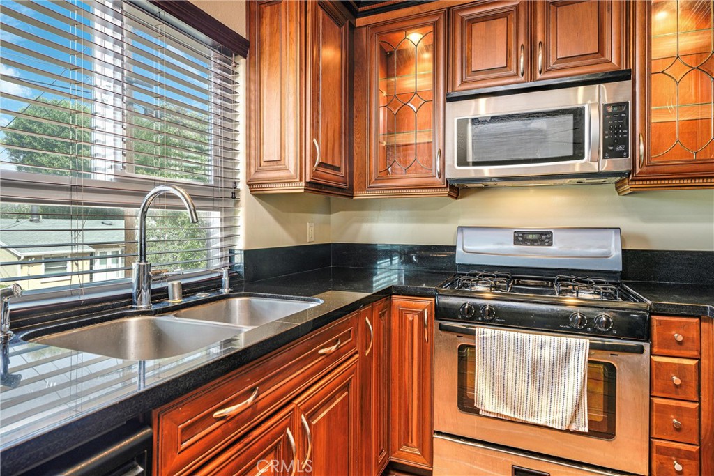 7267 Corbin Avenue, Unit M Winnetka, CA 91306 - Photo 9 of 28 a kitchen with stainless steel appliances granite countertop a sink a stove and cabinets