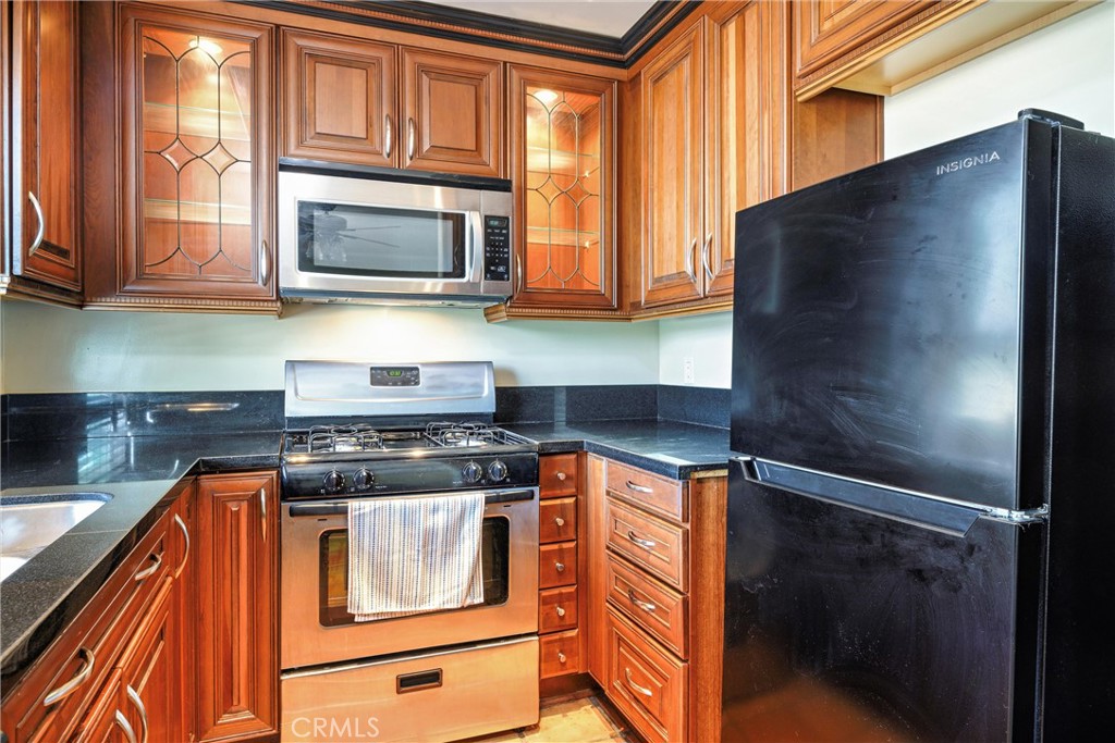 7267 Corbin Avenue, Unit M Winnetka, CA 91306 - Photo 10 of 28 a kitchen with stainless steel appliances granite countertop a refrigerator and a stove top oven