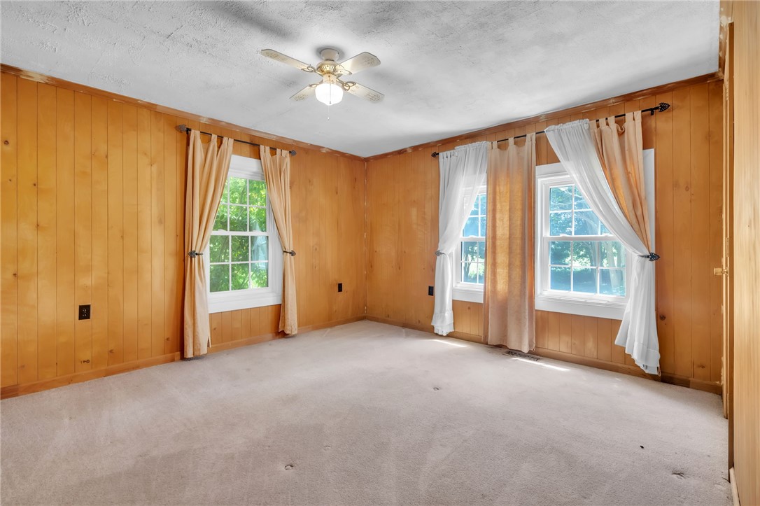 602 Harper Road Pendleton, SC 29670 - Photo 14 of 32 Four windows illuminate this generously sized bedroom, complete with wood paneling and plush carpeting.