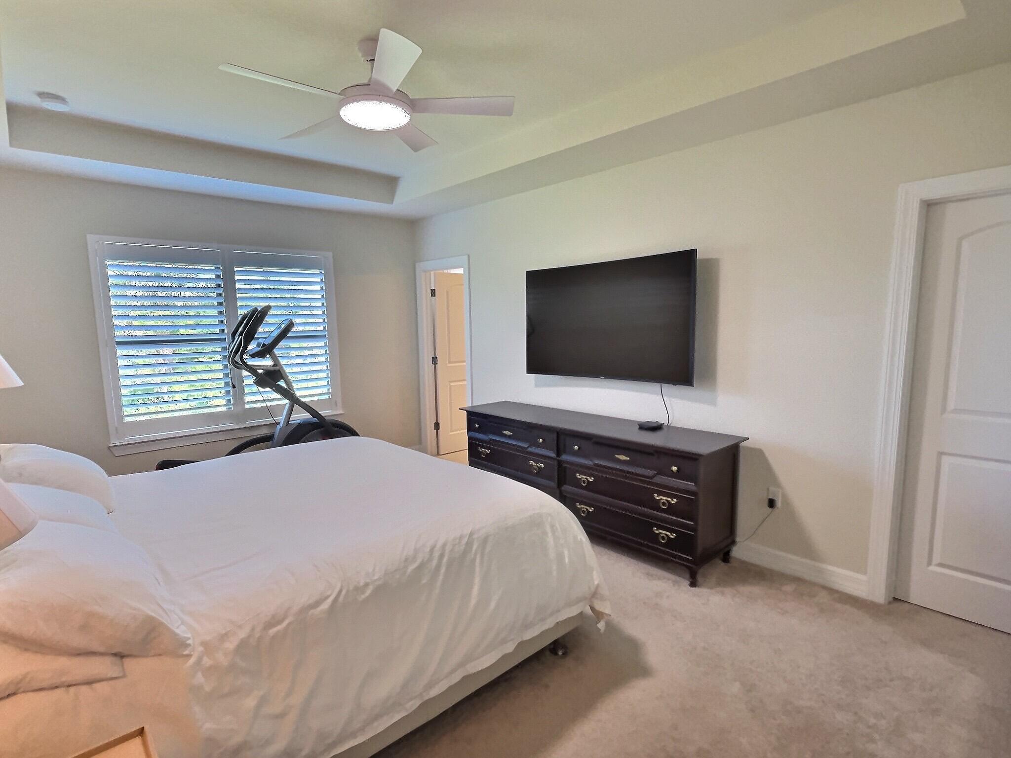 4829 Chantilly Road Lake Worth, FL 33467 - Photo 9 of 31 a bedroom with a bed and a flat tv screen on dresser