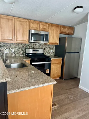 a kitchen with stainless steel appliances granite countertop a refrigerator a stove top oven a sink and dishwasher