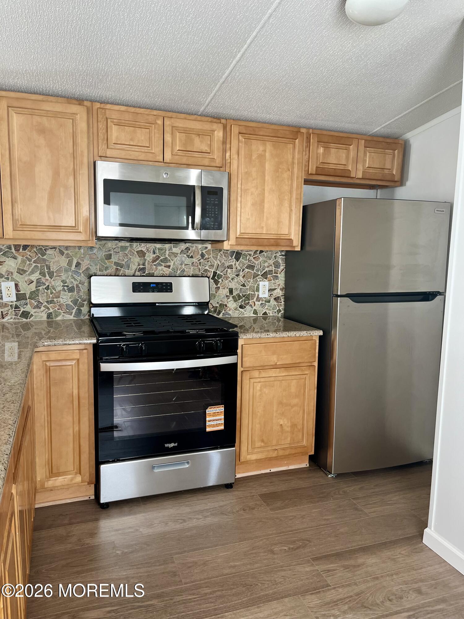58 Ron Road Hazlet, NJ 07730 - Photo 4 of 9 a kitchen with granite countertop a refrigerator stove and microwave