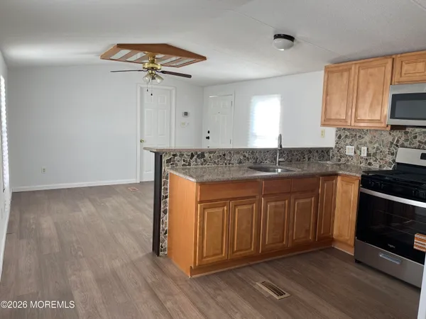 a kitchen with granite countertop a sink cabinets and wooden floor