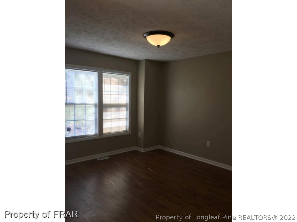 1065 Roundabout Road Cameron, NC 28326 - Photo 9 of 25 a view of an empty room with wooden floor and a window