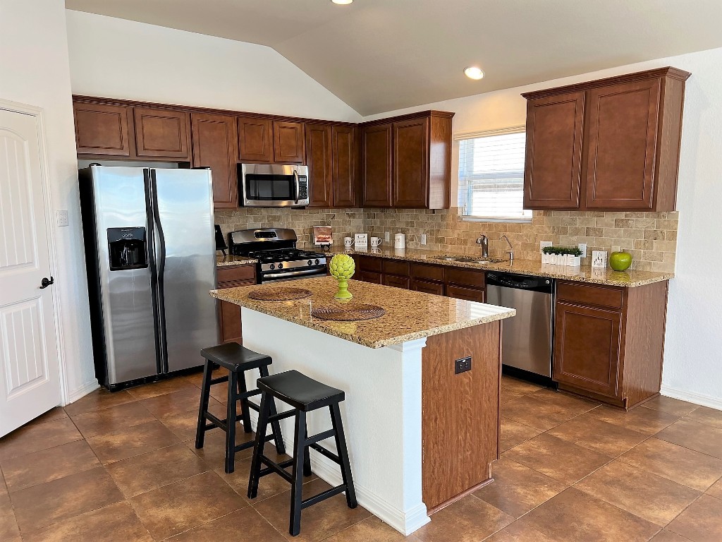 1711 Hidden Springs Path Round Rock, TX 78665 - Photo 12 of 39 a kitchen with stainless steel appliances granite countertop a stove top oven a refrigerator a sink and dishwasher