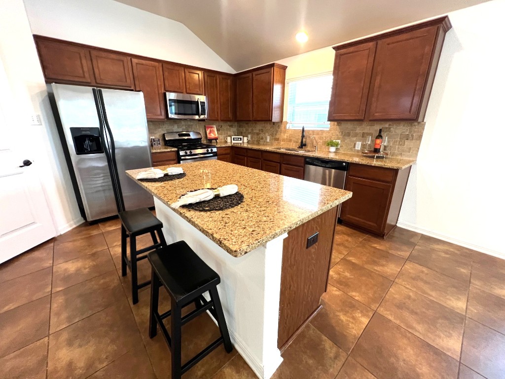 1711 Hidden Springs Path Round Rock, TX 78665 - Photo 8 of 39 a kitchen with granite countertop wood cabinets a sink a stove a refrigerator and cabinets