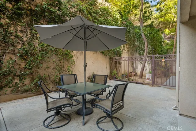 a view of patio with furniture and table under an umbrella