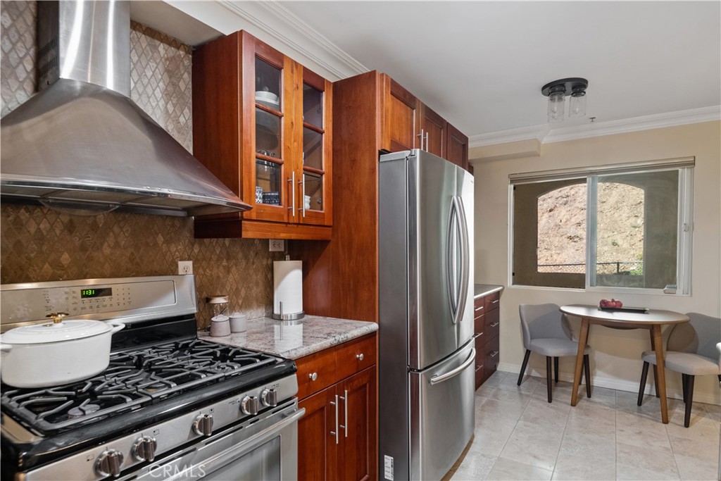 6221 Monterey Road, Unit 304 Highland Park, CA 90042 - Photo 6 of 33 a kitchen with stainless steel appliances granite countertop a stove a refrigerator and a dining table