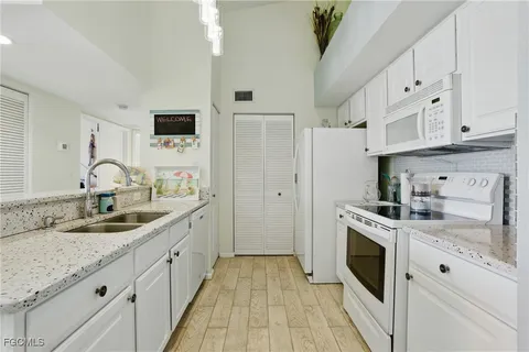 a kitchen with granite countertop a sink stove and refrigerator