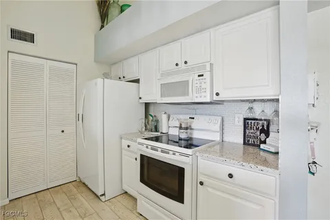 a kitchen with stainless steel appliances white cabinets and a refrigerator