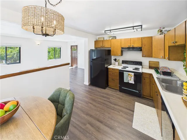a kitchen with cabinets wooden floor and a dining table