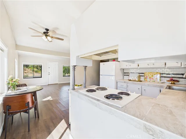 a kitchen with a stove a table and chairs in it
