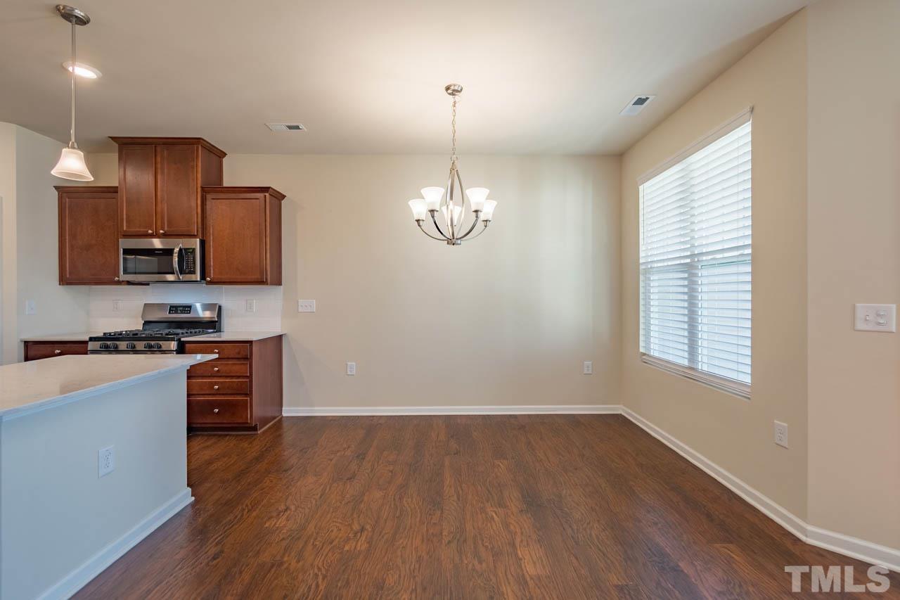 6072 Beale Loop Raleigh, NC 27616 - Photo 14 of 33 a kitchen with stainless steel appliances granite countertop a stove a sink dishwasher a refrigerator and a stove with wooden floor