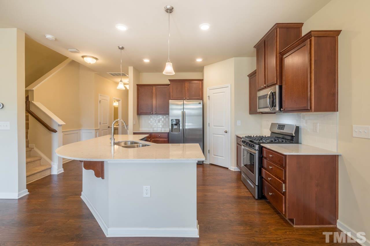 6072 Beale Loop Raleigh, NC 27616 - Photo 8 of 33 a large kitchen with kitchen island a sink a stove and a refrigerator