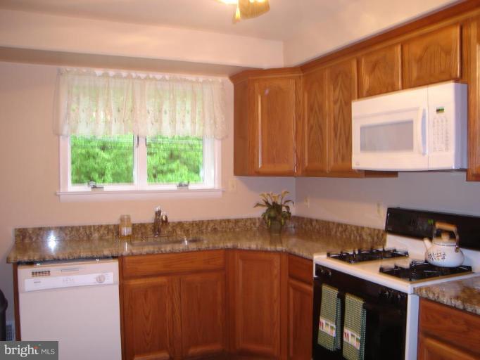 1502 Draper Court Rosedale, MD 21237 - Photo 2 of 10 a kitchen with stainless steel appliances granite countertop a sink stove and cabinets