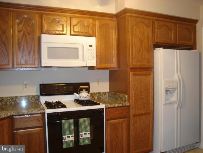 1502 Draper Court Rosedale, MD 21237 - Photo 3 of 10 a kitchen with stainless steel appliances granite countertop a refrigerator and a stove top oven