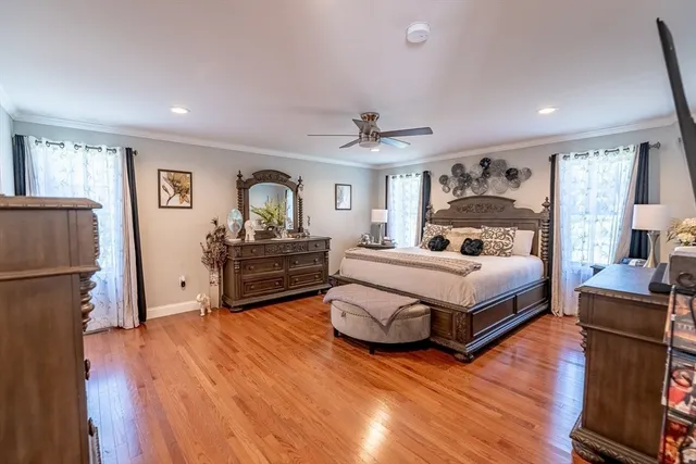a large bedroom with a bed and wooden floor
