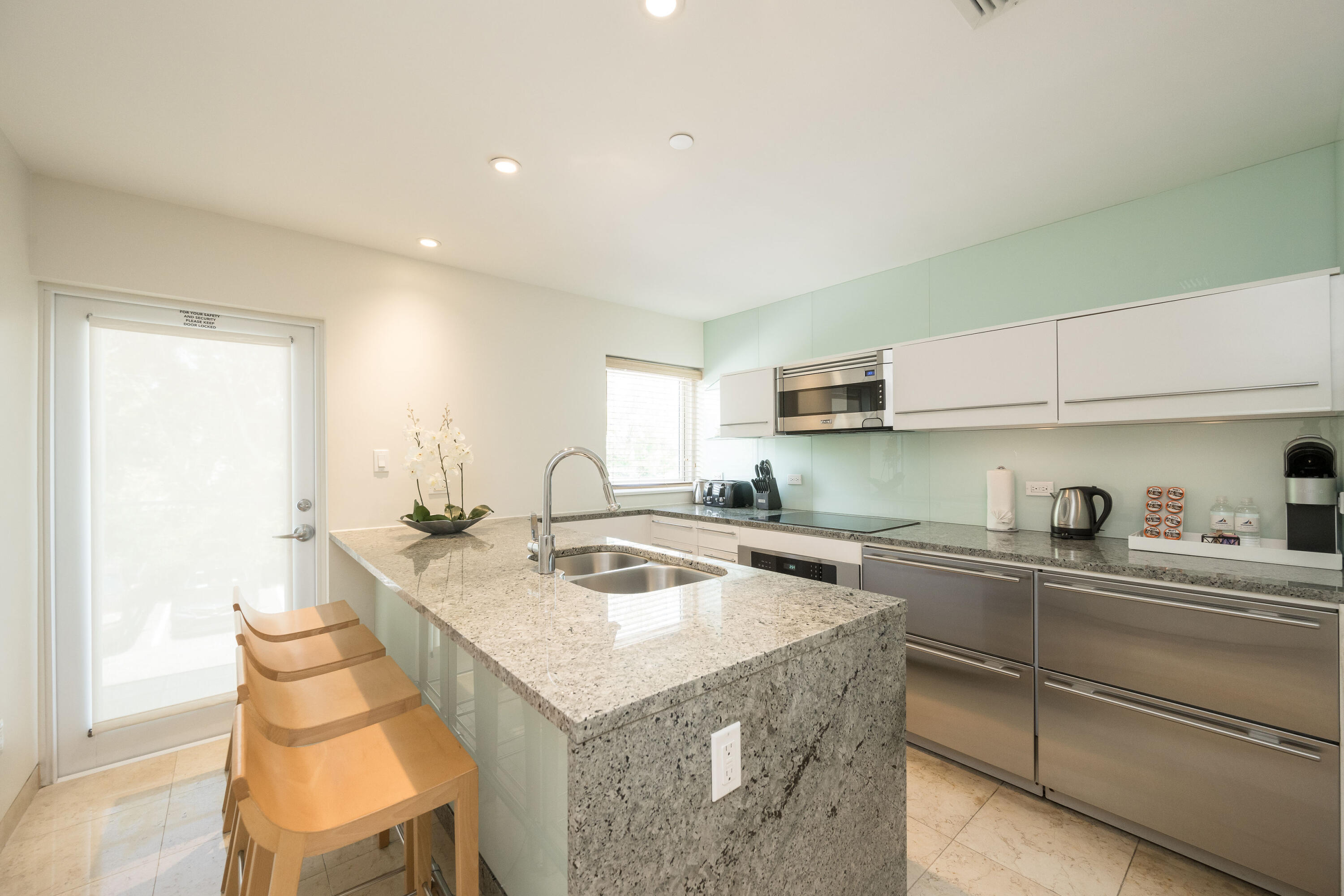 1401 Simonton Street, Unit 20 Key West, FL 33040 - Photo 8 of 32 a kitchen with a sink a stove and chairs