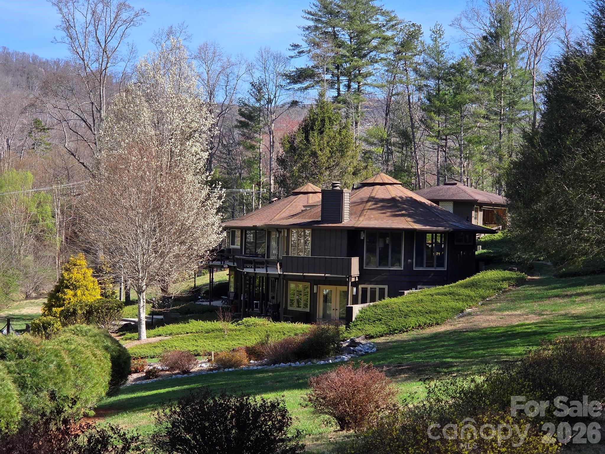 a view of a house with a big yard and large trees