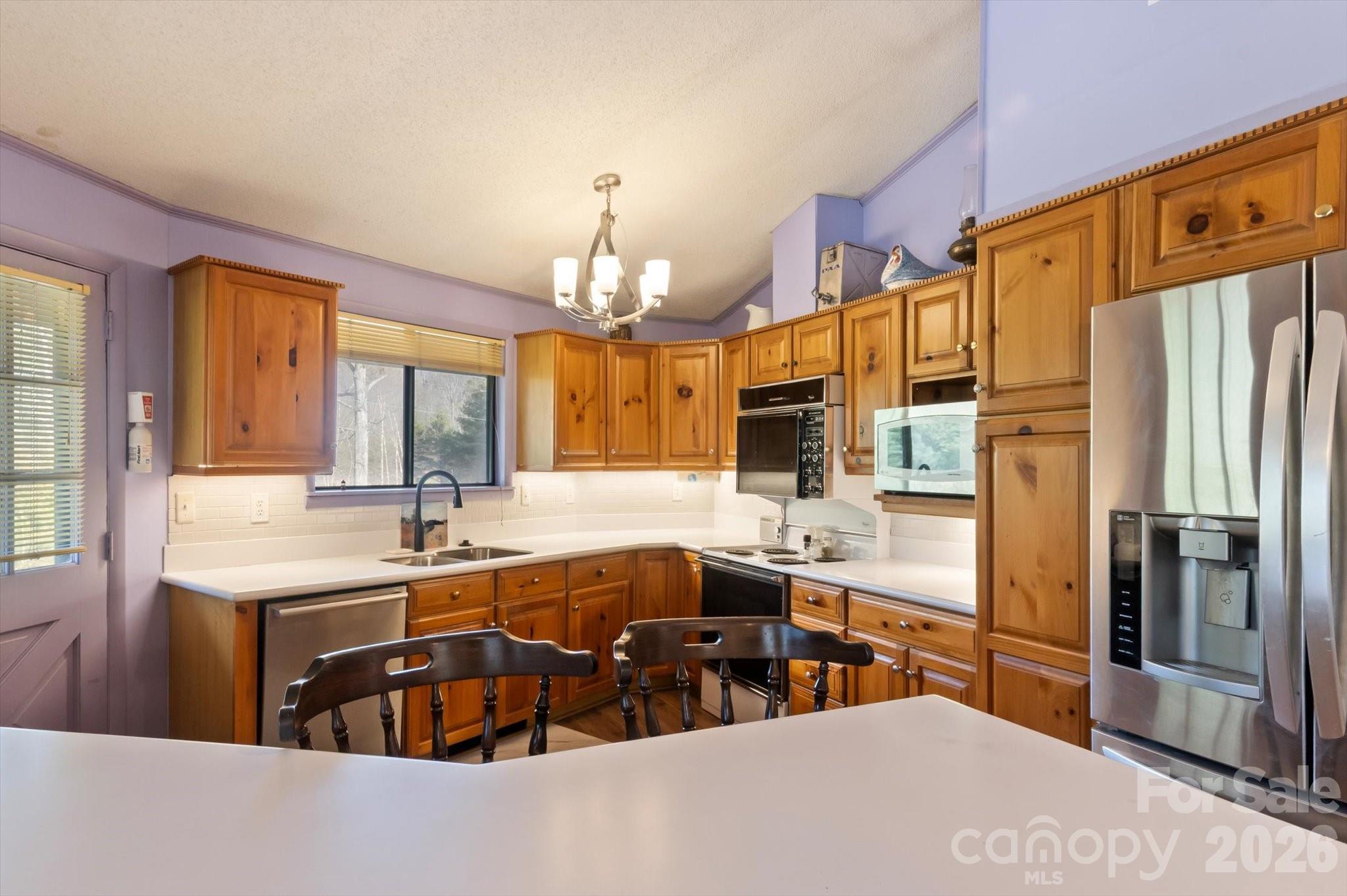 1881 Brookside Camp Road Hendersonville, NC 28792 - Photo 17 of 48 a kitchen with stainless steel appliances granite countertop a sink refrigerator and cabinets