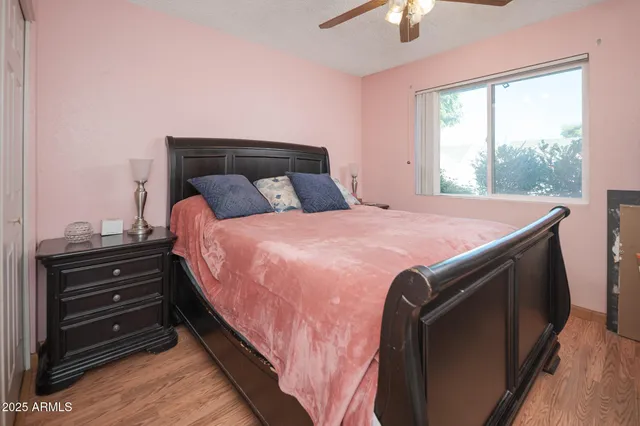 a bedroom with a bed and a chandelier fan