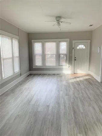 an empty room with wooden floor and windows