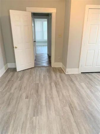 a view of an empty room with closet and a window