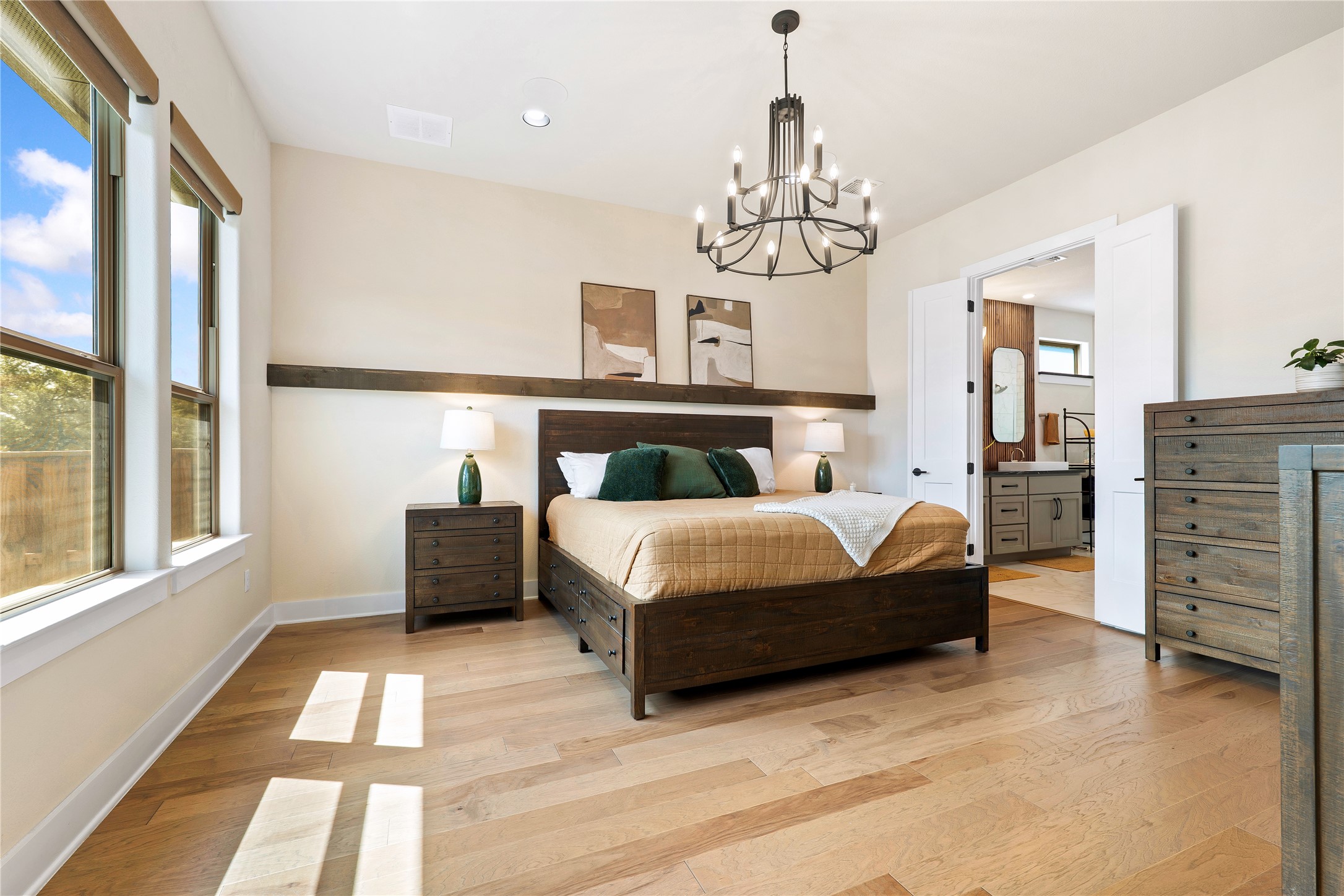 2408 Nate's Place Georgetown, TX 78633 - Photo 17 of 40 Hardwood floors and generous natural light create an inviting atmosphere in this primary bedroom suite.