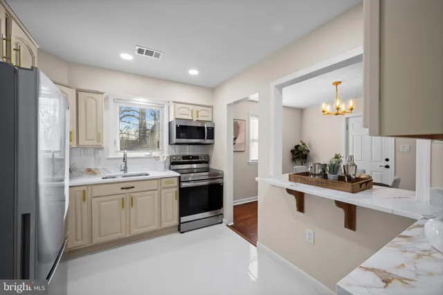 a kitchen with stainless steel appliances a sink stove and refrigerator