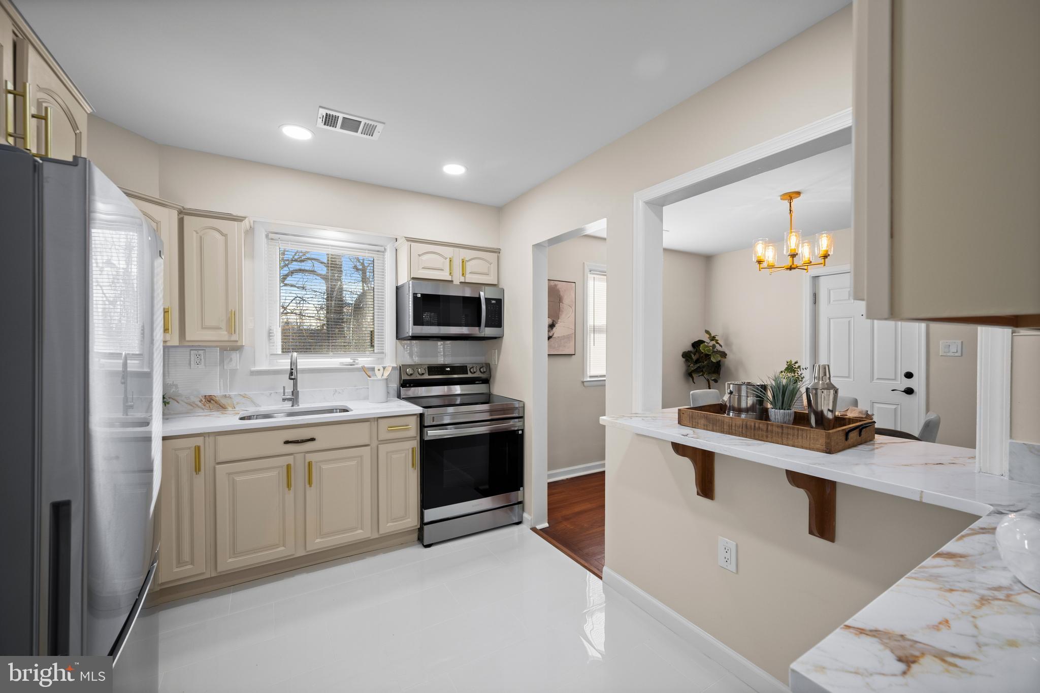 8711 Windsor Mill Road Windsor Mill, MD 21244 - Photo 13 of 35 a kitchen with stainless steel appliances a sink stove and refrigerator