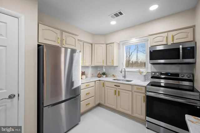 a kitchen with stainless steel appliances a refrigerator sink and microwave