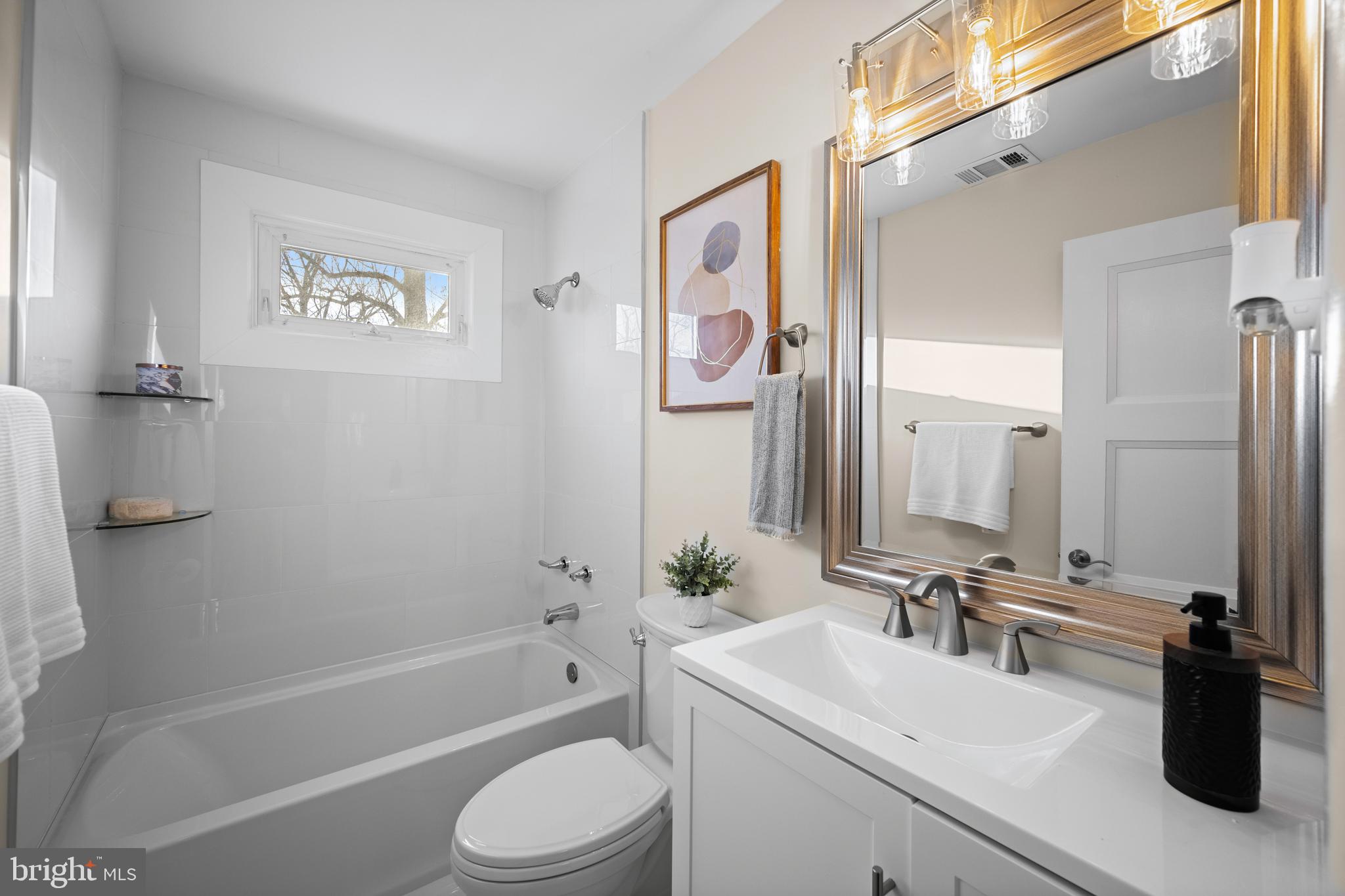 8711 Windsor Mill Road Windsor Mill, MD 21244 - Photo 15 of 35 a bathroom with a bathtub shower sink vanity and toilet
