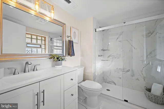 a bathroom with a sink a toilet and shower