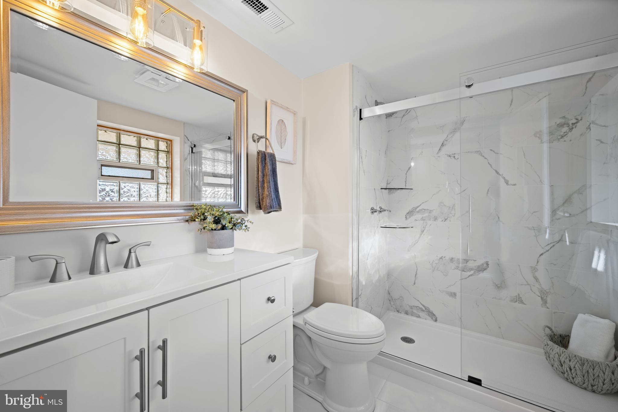 8711 Windsor Mill Road Windsor Mill, MD 21244 - Photo 16 of 35 a bathroom with a sink a toilet and shower