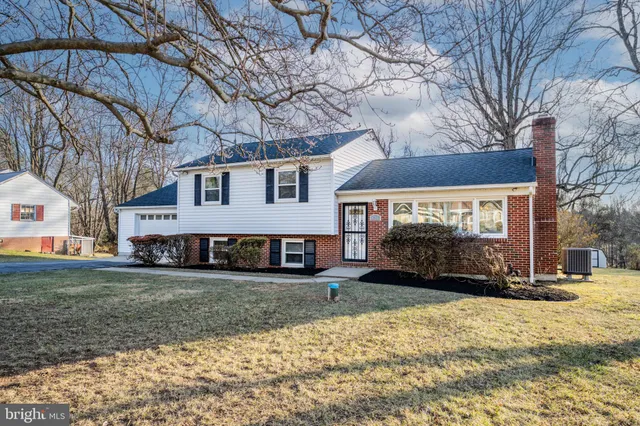 a view of a white house that has a tree on the side of it
